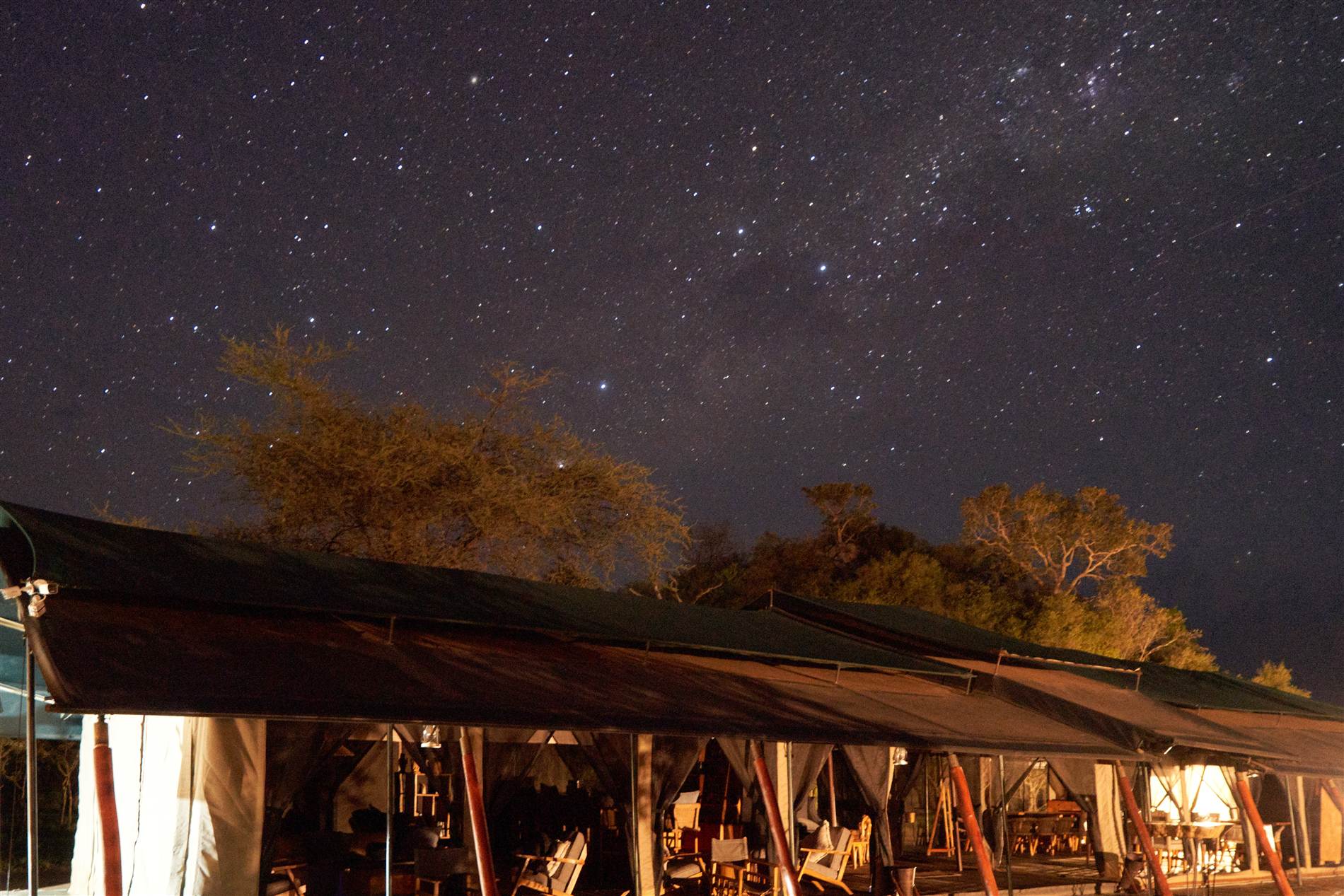 Nyumbani Camp's mess tent glowing under the Milky Way in the central Serengeti